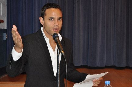 Daniel Sunjata delivering speech in a white shirt and black suit.
